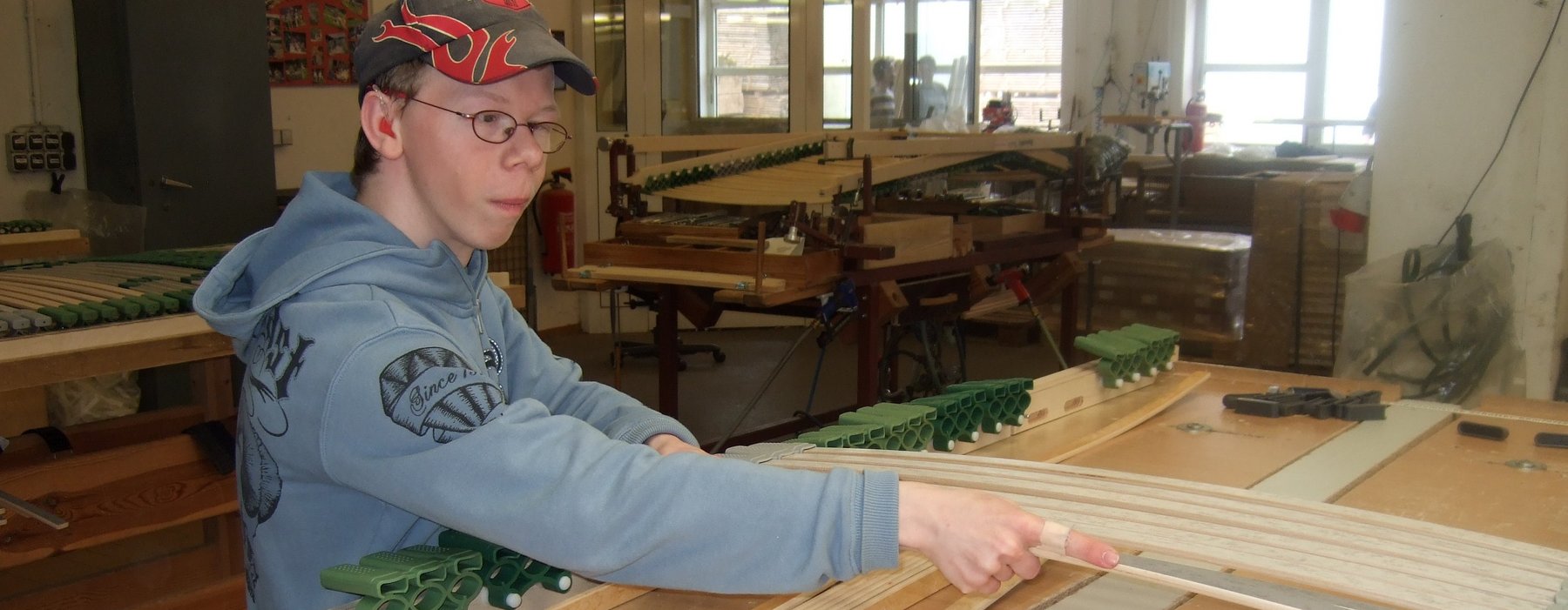 Ein Junge baut ein Lattenrost zusammen.